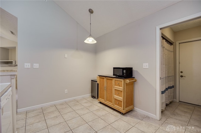 kitchen with decorative light fixtures, baseboards, black microwave, and light tile patterned floors