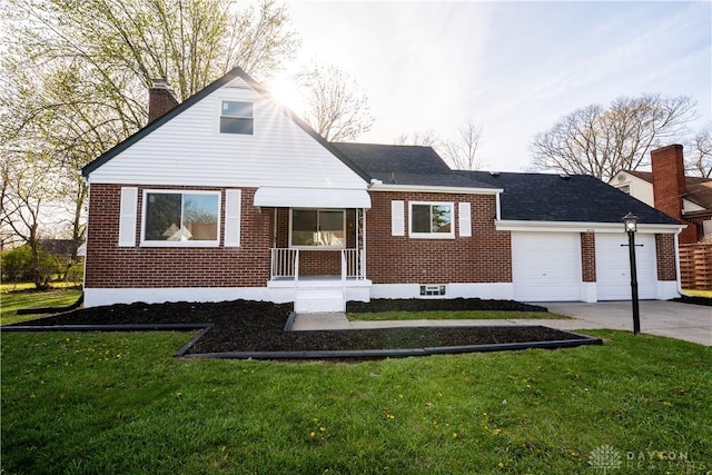 view of front facade with a chimney, brick siding, a front yard, and concrete driveway