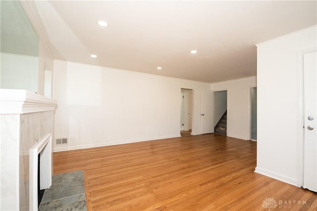 unfurnished living room featuring stairway, recessed lighting, visible vents, and light wood-type flooring