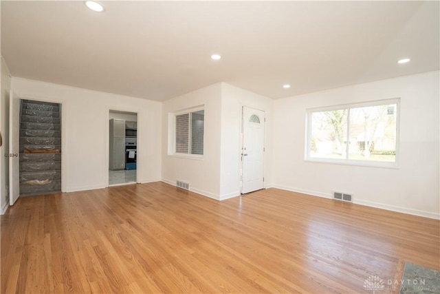 unfurnished living room with visible vents and baseboards