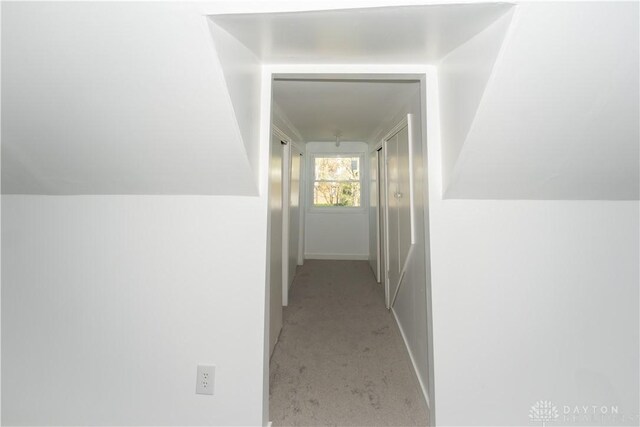 hallway with light carpet and baseboards