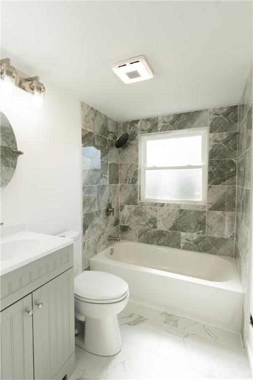 bathroom with bathing tub / shower combination, marble finish floor, vanity, and toilet
