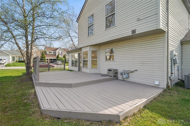 wooden deck featuring a lawn and central AC unit
