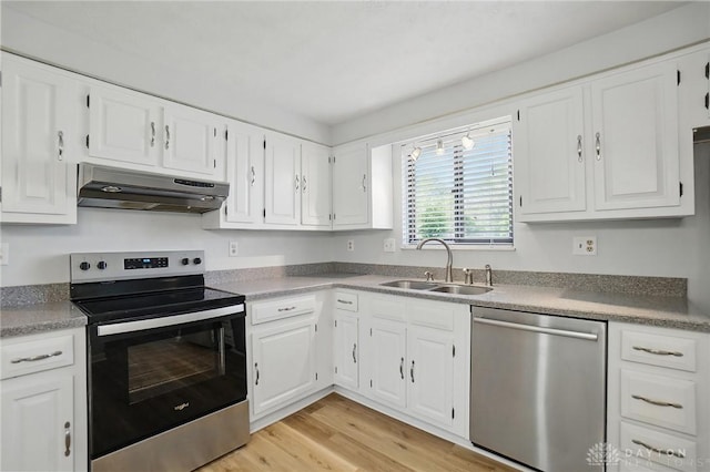 kitchen featuring white cabinets, appliances with stainless steel finishes, under cabinet range hood, and a sink