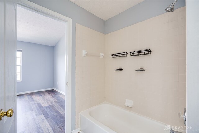 2454 Cabbage Key Dr, Miamisburg, OH 45342 - bathroom with baseboards, shower / bathtub combination, wood finished floors, and a textured ceiling