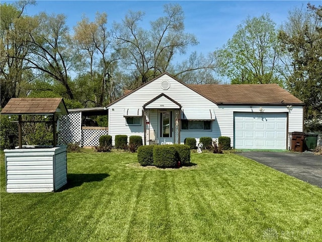 bungalow-style home featuring a front lawn, aphalt driveway, and a garage