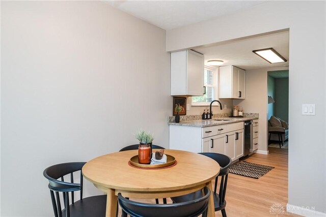 dining room featuring light wood finished floors and baseboards