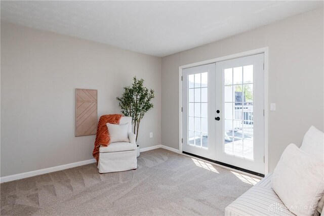 living area with baseboards, french doors, and carpet flooring