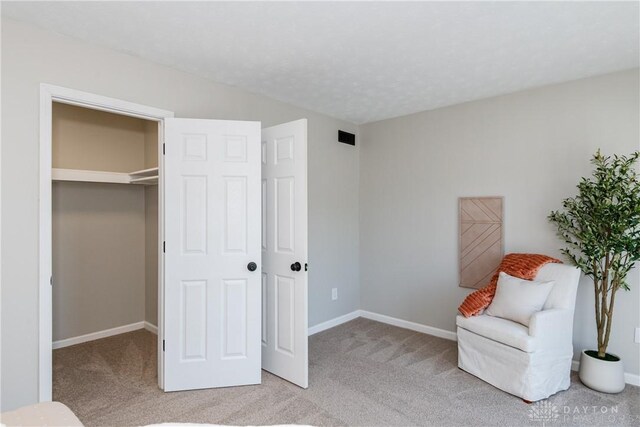 living area with visible vents, baseboards, and carpet flooring