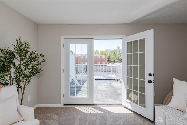 doorway with carpet floors and baseboards