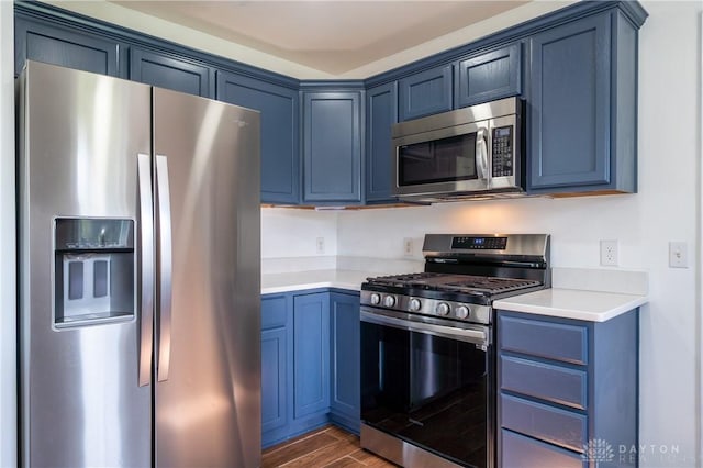 4100 Joshane St, Springfield, OH 45502 - kitchen featuring blue cabinets, stainless steel appliances, dark wood-type flooring, and light countertops