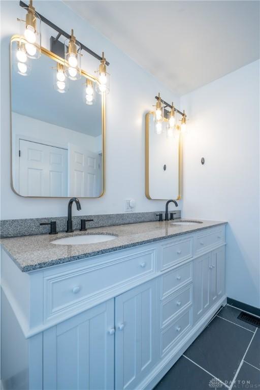 4100 Joshane St, Springfield, OH 45502 - full bathroom with double vanity, tile patterned floors, baseboards, and a sink