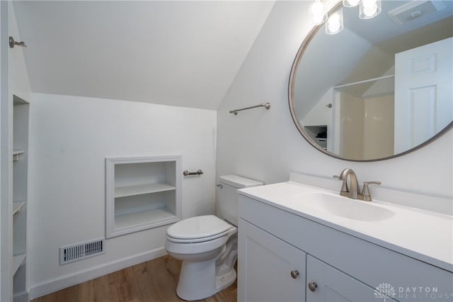 4100 Joshane St, Springfield, OH 45502 - bathroom with vaulted ceiling, wood finished floors, built in shelves, toilet, and visible vents