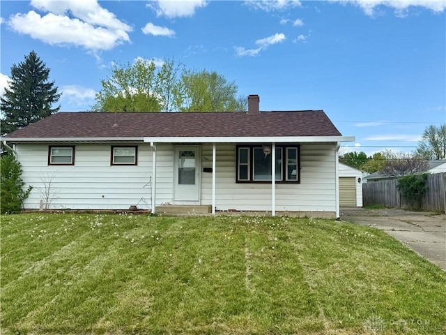 ranch-style house with a chimney, a front lawn, fence, and a shingled roof