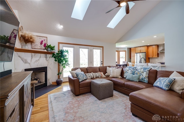 9171 Big Oak Dr, Washington Twp, OH 45458 - living room featuring a skylight, ceiling fan, light wood-style floors, a high end fireplace, and recessed lighting