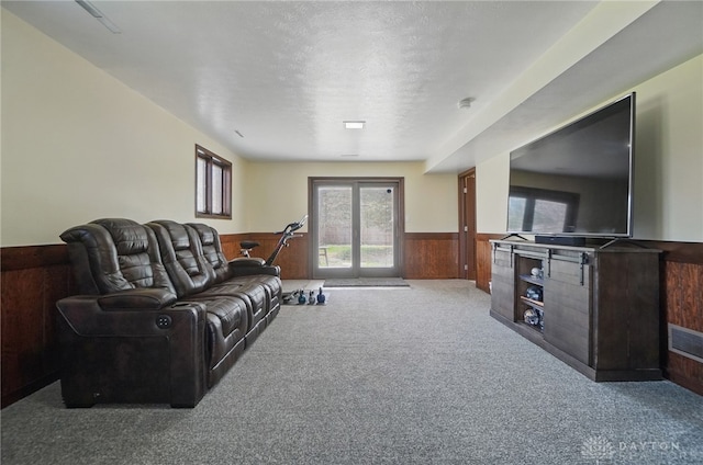 living area featuring wooden walls, carpet floors, and a wainscoted wall