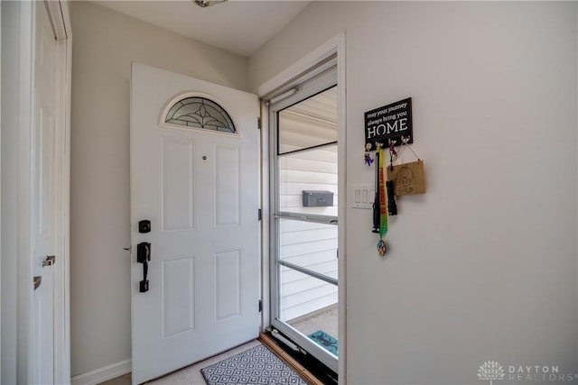 doorway with baseboards and light tile patterned floors