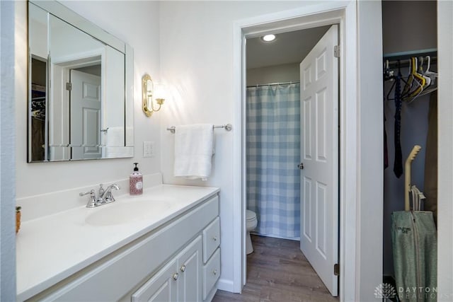 bathroom with recessed lighting, vanity, curtained shower, toilet, and wood finished floors