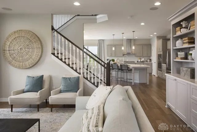 living area featuring recessed lighting, dark wood finished floors, baseboards, and stairway