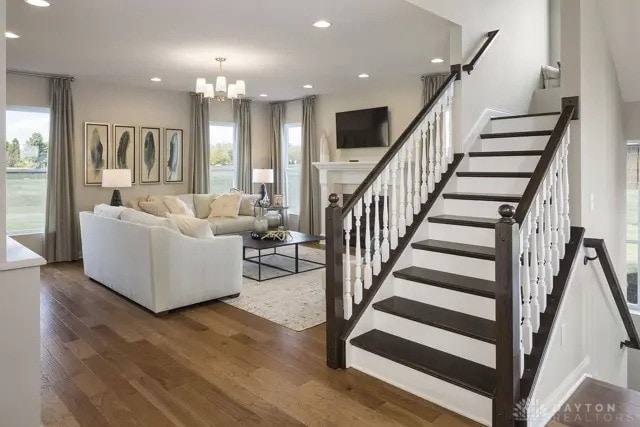 living area featuring recessed lighting, a chandelier, wood finished floors, and stairway
