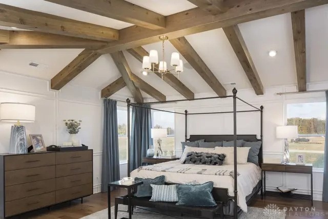 bedroom featuring a chandelier, vaulted ceiling with beams, and wood finished floors