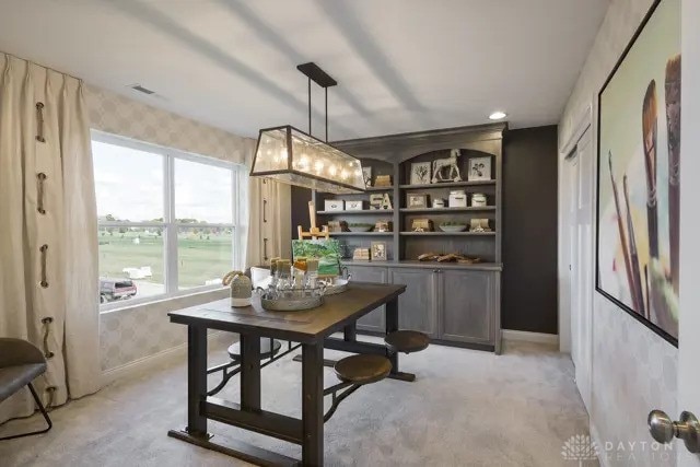 dining space featuring baseboards, light carpet, and wallpapered walls