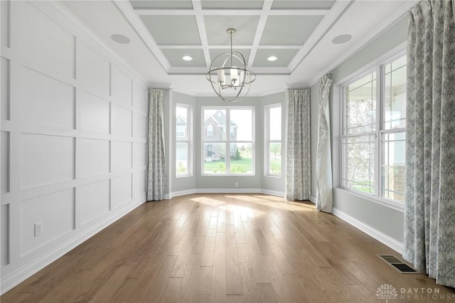 unfurnished dining area featuring visible vents, ornamental molding, baseboards, a chandelier, and coffered ceiling