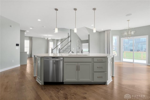 kitchen featuring stainless steel dishwasher, a sink, dark wood-style floors, and an inviting chandelier