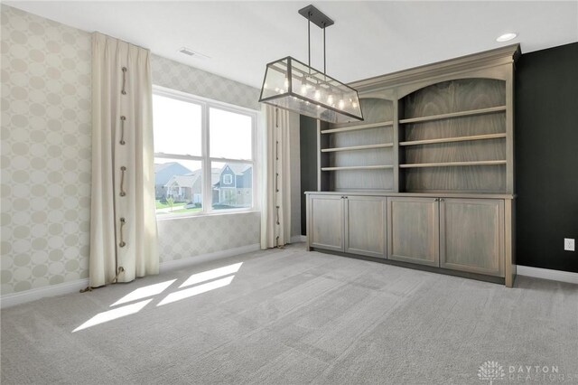 interior space featuring visible vents, baseboards, light carpet, and wallpapered walls