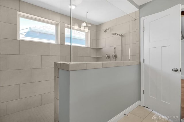 full bathroom featuring a walk in shower, tile patterned flooring, and baseboards