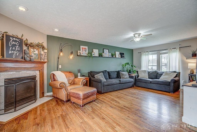 631 Alpine Pl, Trenton, OH 45067 - living area featuring a fireplace, wood finished floors, a textured ceiling, and ceiling fan