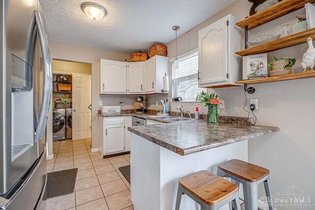 631 Alpine Pl, Trenton, OH 45067 - kitchen with a sink, stainless steel fridge, washer and dryer, a peninsula, and white cabinetry