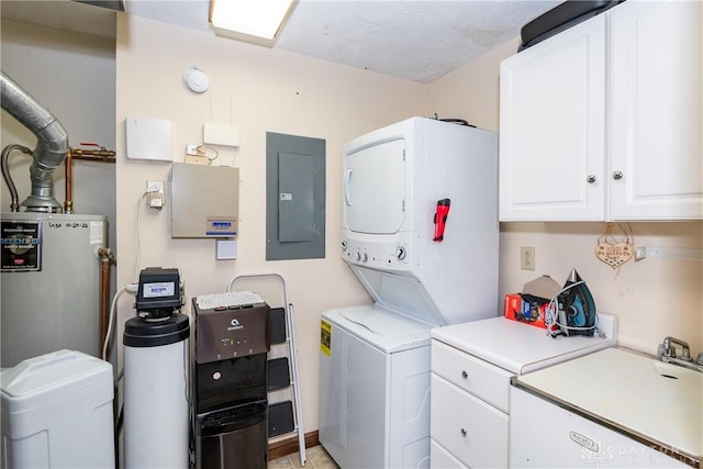washroom featuring a sink, electric panel, water heater, cabinet space, and stacked washer and clothes dryer