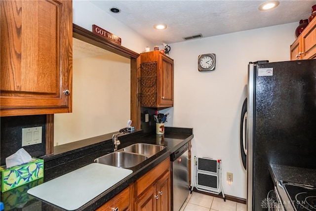 kitchen featuring brown cabinets, visible vents, appliances with stainless steel finishes, and a sink