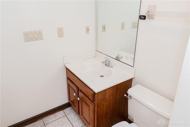 half bath with toilet, vanity, and tile patterned floors