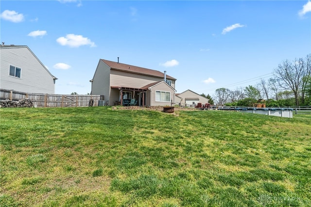 back of house featuring fence and a lawn