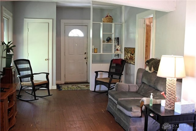 living area featuring baseboards and hardwood / wood-style flooring