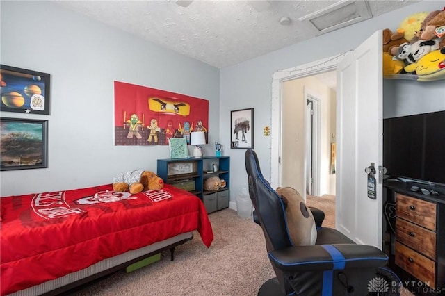 carpeted bedroom featuring attic access and a textured ceiling