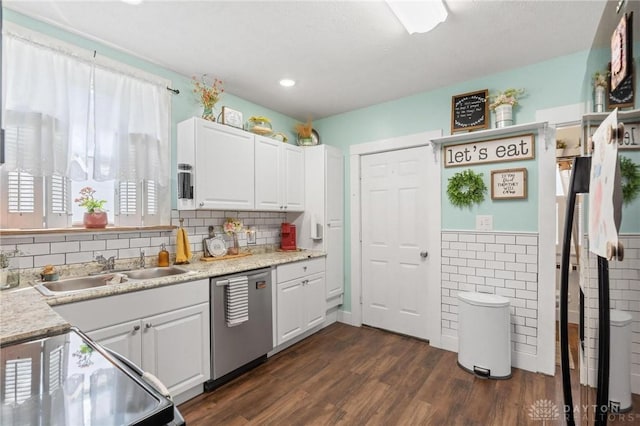 kitchen featuring white cabinetry, light countertops, stainless steel dishwasher, and a sink