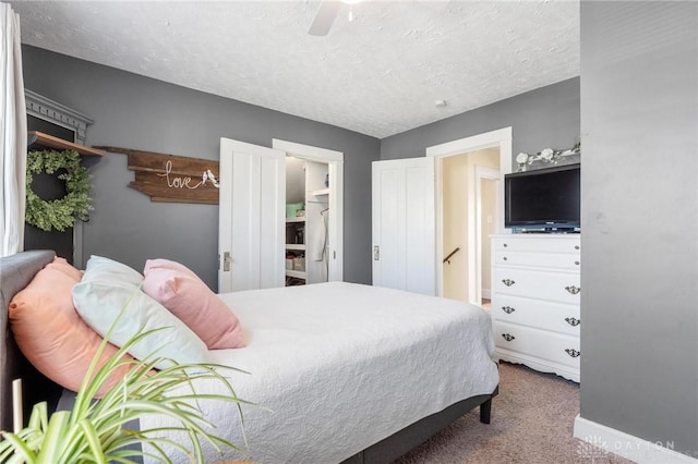 bedroom featuring a textured ceiling, ceiling fan, carpet, and baseboards