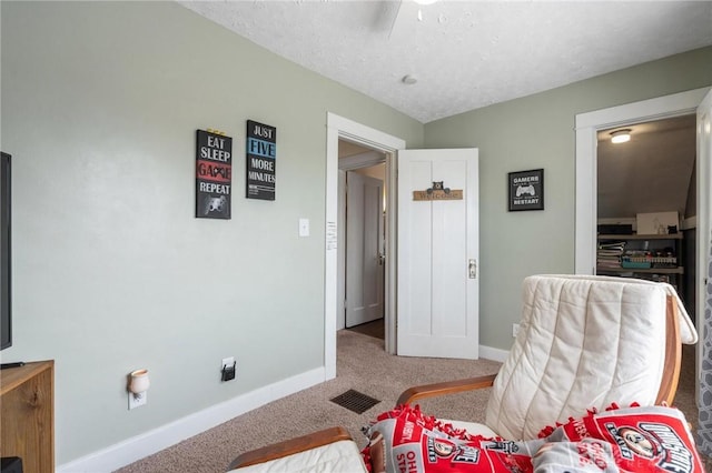 living area with baseboards, a ceiling fan, and carpet flooring