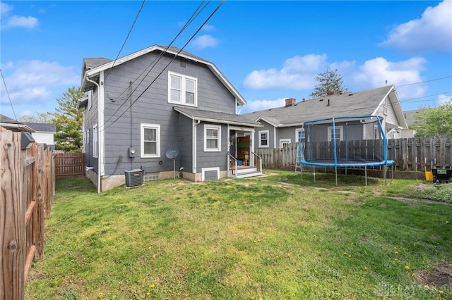 rear view of house with a yard and a fenced backyard