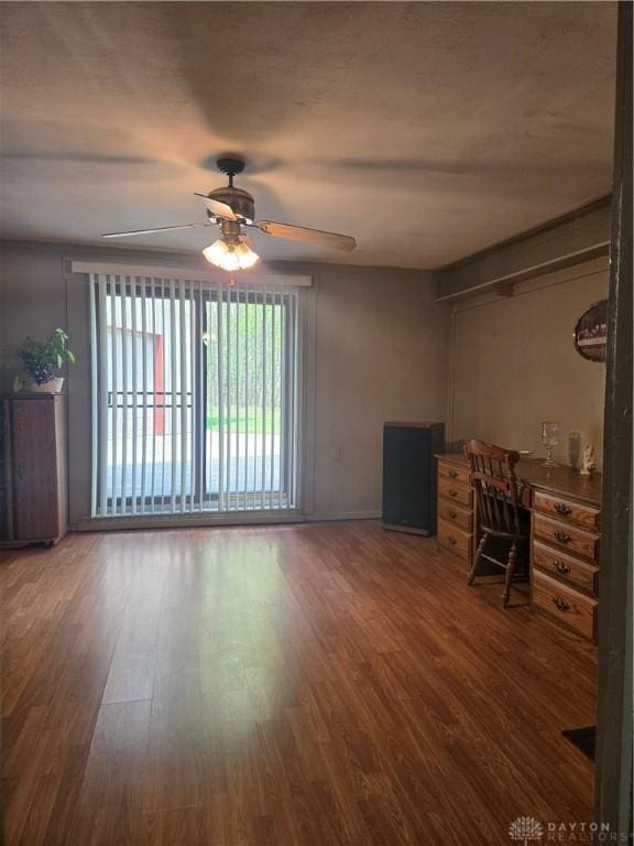 unfurnished living room with wood finished floors and a ceiling fan