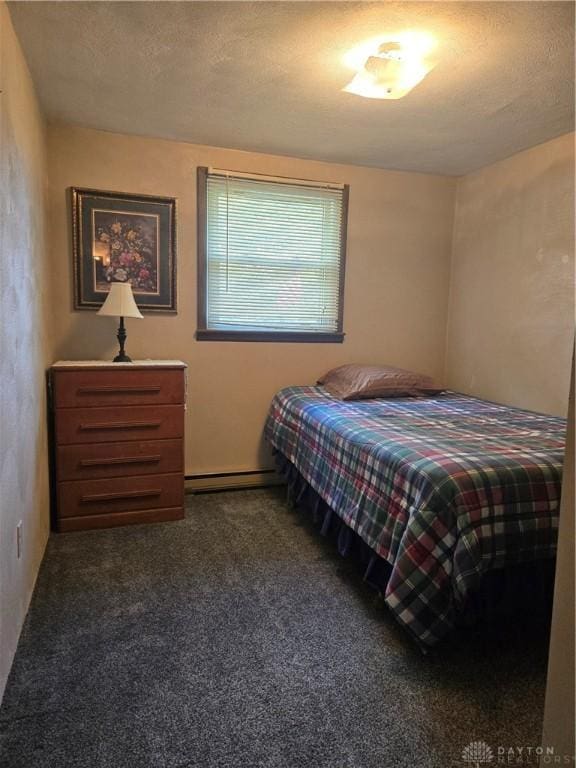 bedroom with a textured ceiling, carpet flooring, and baseboard heating
