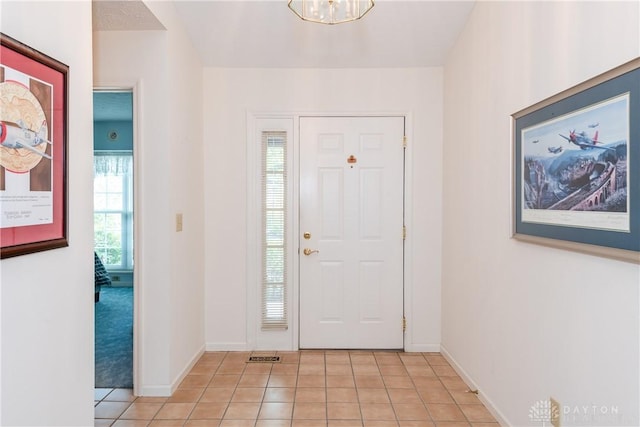 foyer featuring baseboards and light tile patterned floors