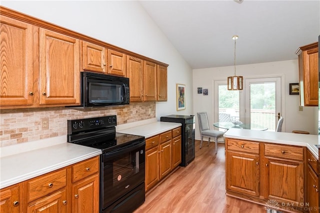 kitchen with brown cabinetry, black appliances, and vaulted ceiling