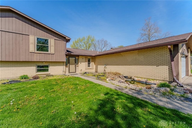 view of front facade with a front lawn and brick siding