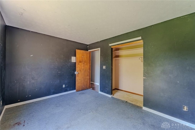 unfurnished bedroom featuring a closet, carpet, and baseboards