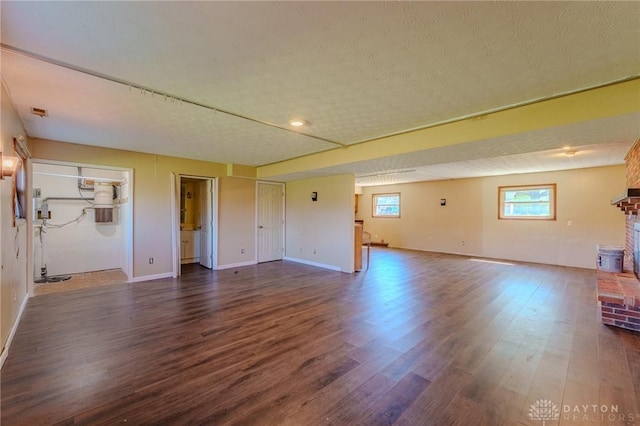 interior space with a fireplace, baseboards, and dark wood-type flooring