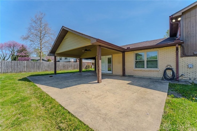view of patio / terrace with concrete driveway, a ceiling fan, a carport, and fence